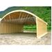 Tunnel de stockage en PVC, vu de profil à mi-distance, avec une forêt en arrière-plan.